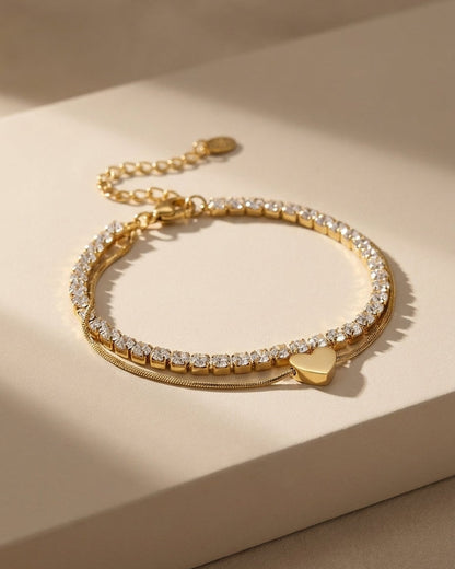 Charm Layered Bracelet featuring a gold rhinestone chain and a thin gold chain with a heart charm.