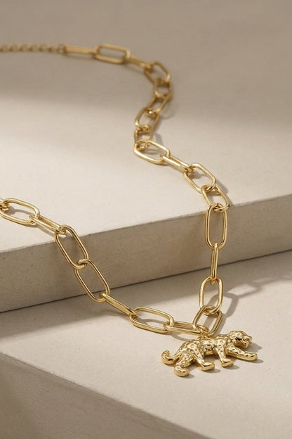 Gold chain necklace with a textured leopard pendant.