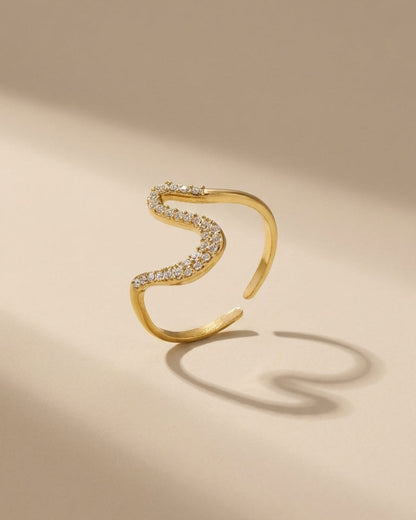Gold Rhinestone Line Ring with an S-curve paved with rhinestones on a neutral background.
