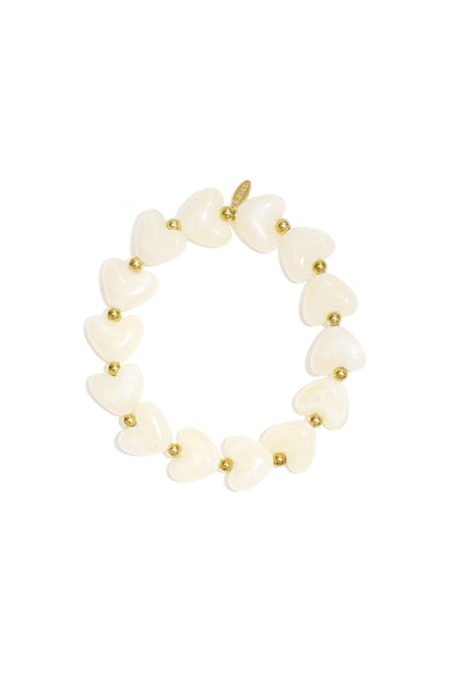 Stretch bracelet featuring alternating cream-colored heart-shaped beads and small gold-tone metal spacers.