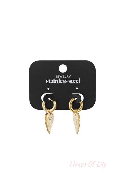 Gold stainless steel hoop earrings with engraved heart pendants on a display card.