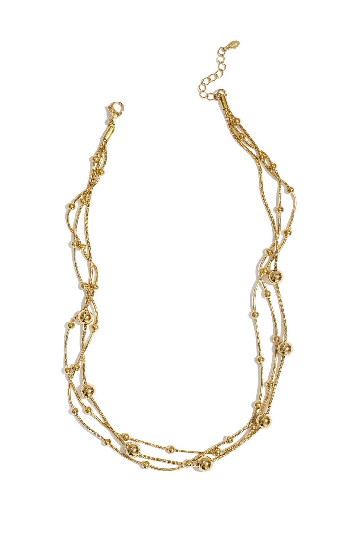 Gold multi-layered necklace with small and large beads laid flat on white background