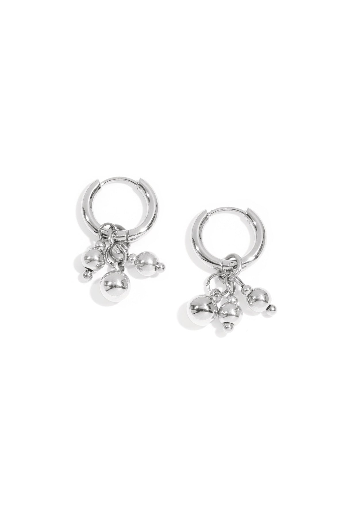 Silver hoop earrings with three small dangling spheres on a white background