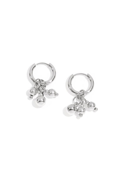Silver hoop earrings with three small dangling spheres on a white background