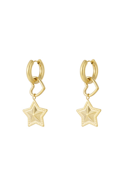 Pair of gold hoop earrings with dangling open heart and textured star charms on white background