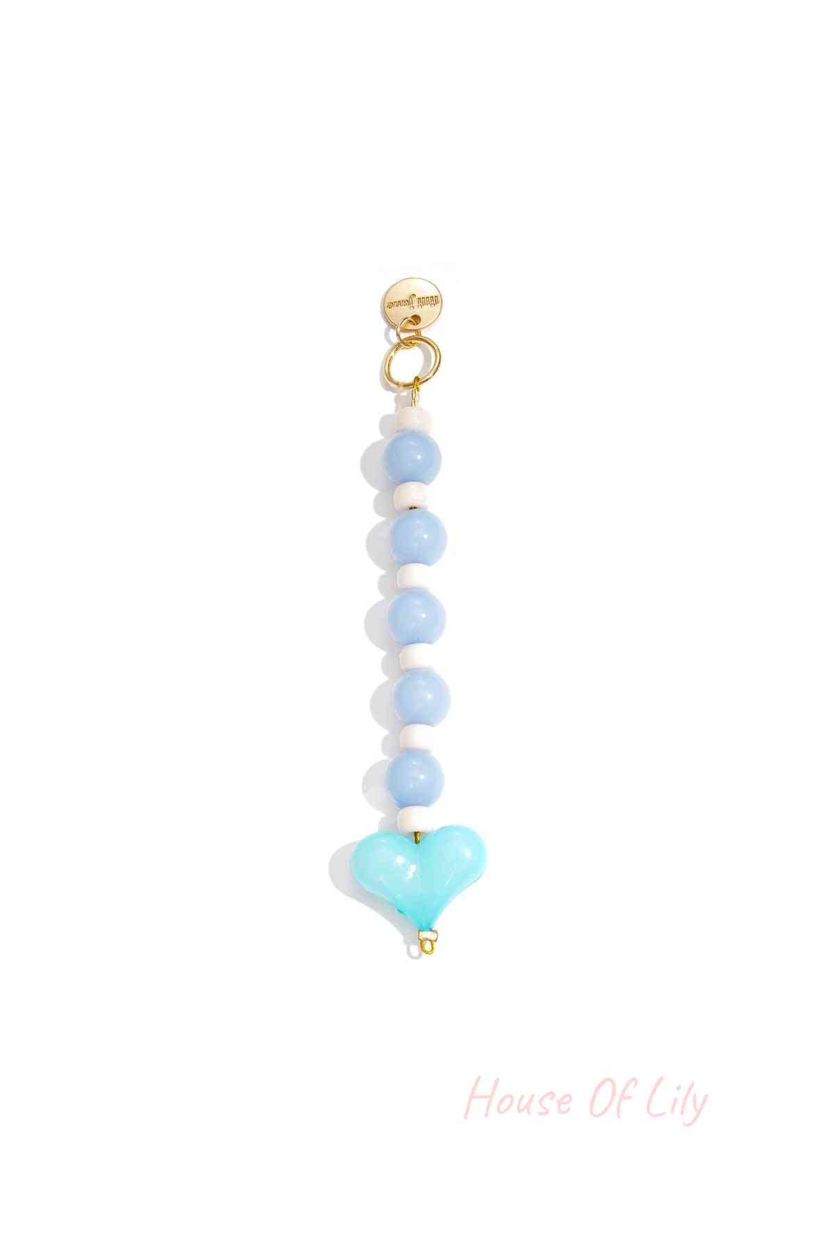 Blue and white heart bead bag charm with gold clasp on white background