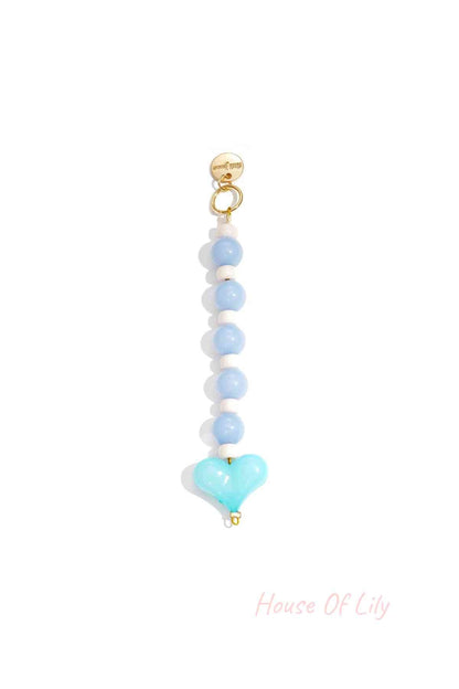 Blue and white heart bead bag charm with gold clasp on white background