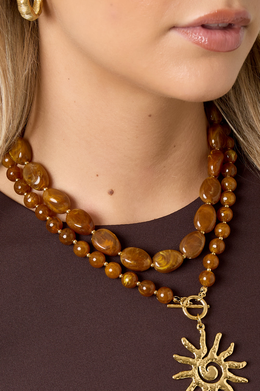 Purple chunky acrylic beaded necklace with gold clasp on white background