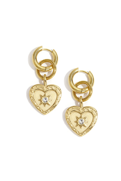 Gold heart charm drop earrings featuring interlocking hoops with rhinestone star detail on white background