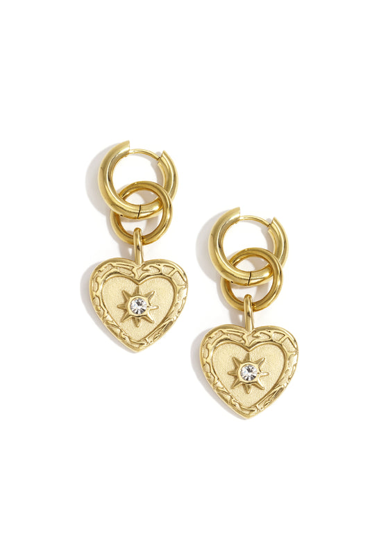 Gold heart charm drop earrings featuring interlocking hoops with rhinestone star detail on white background