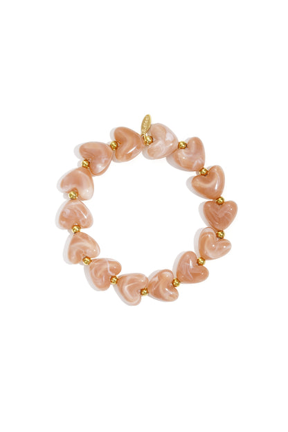 Bright orange marbled heart beaded stretch bracelet with gold accent beads on white background