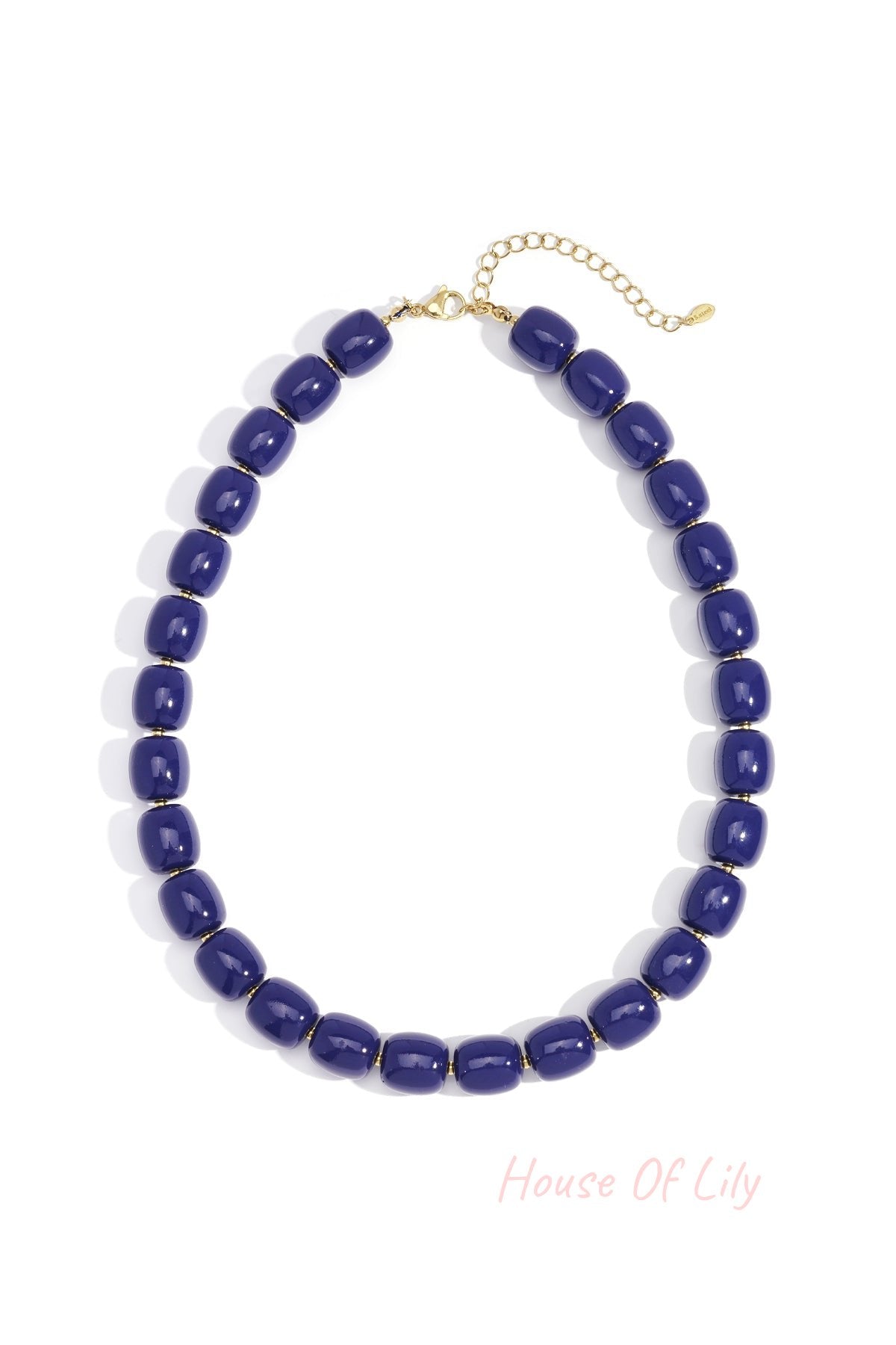 Close-up of navy chunky acrylic bead necklace with gold-tone chain extension on white background