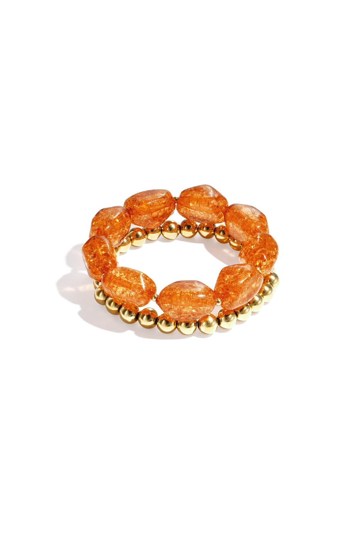 Close-up of orange chunky beaded bracelet set with glossy acrylic and gold-tone beads on white background