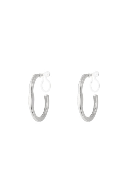 Pair of silver irregular wave-shaped clip-on hoop earrings with clear clip backs on white background