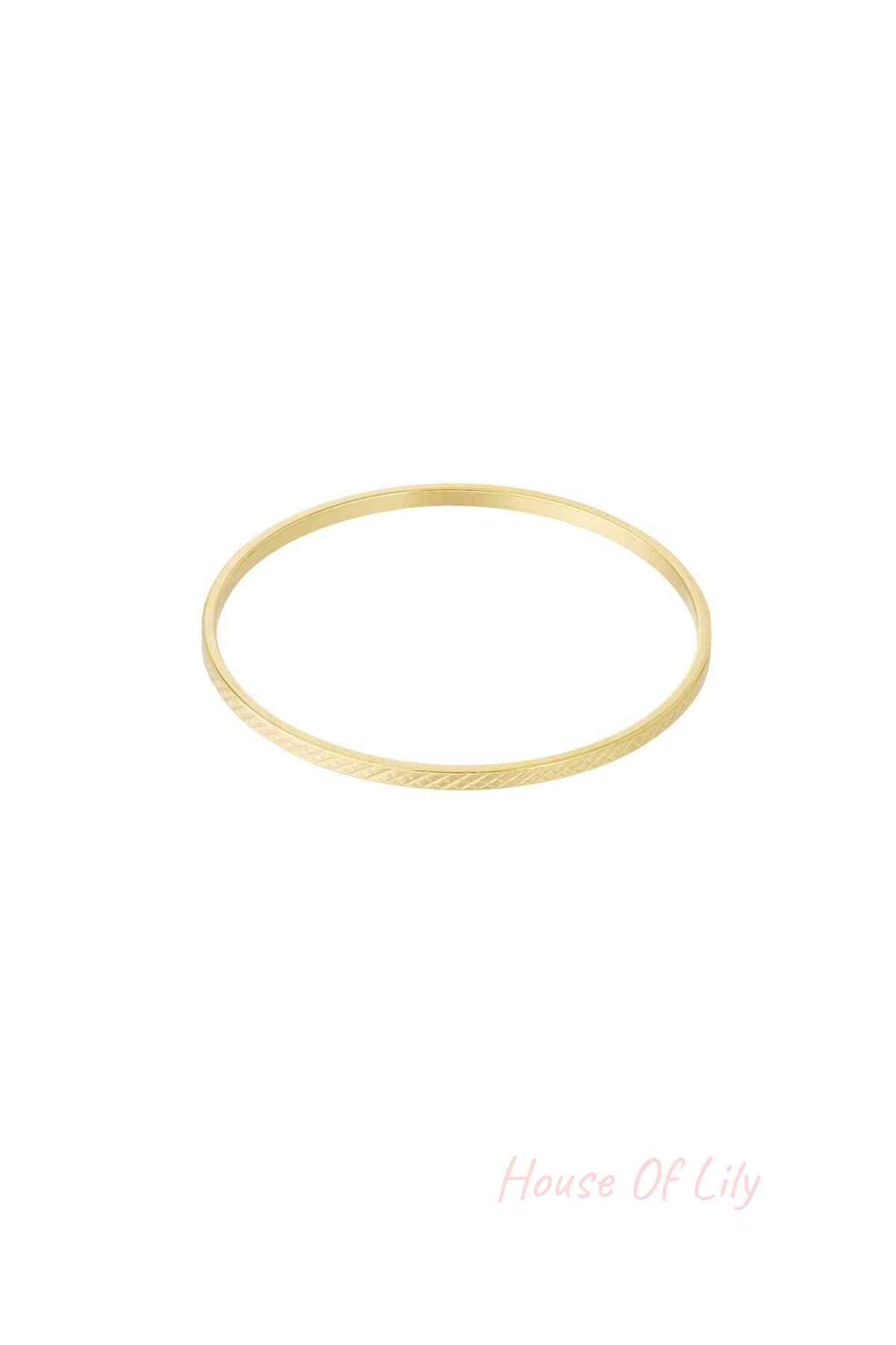 Single slim gold-tone bangle with subtle crosshatch geometric pattern on white background