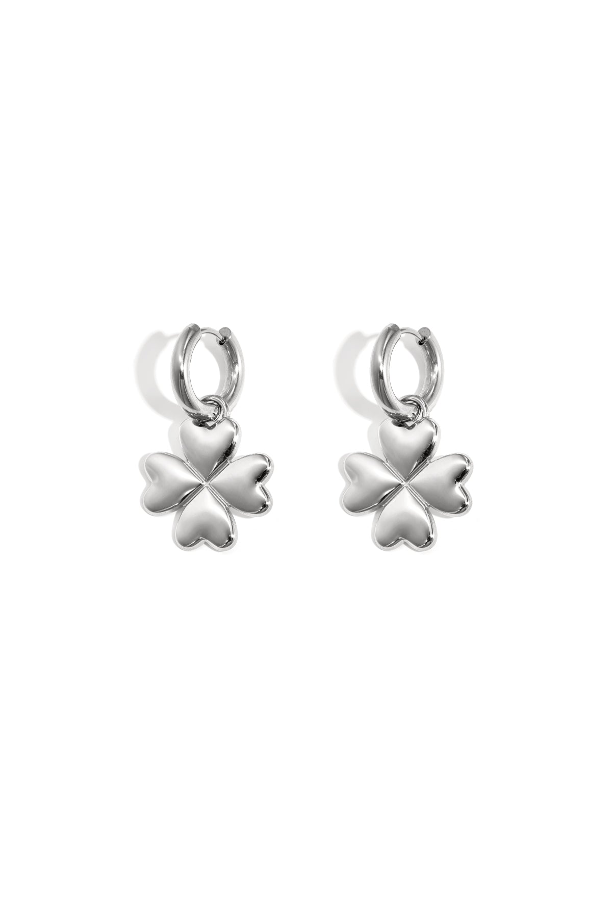 Pair of silver four-leaf clover hoop earrings with heart-shaped petals on white background