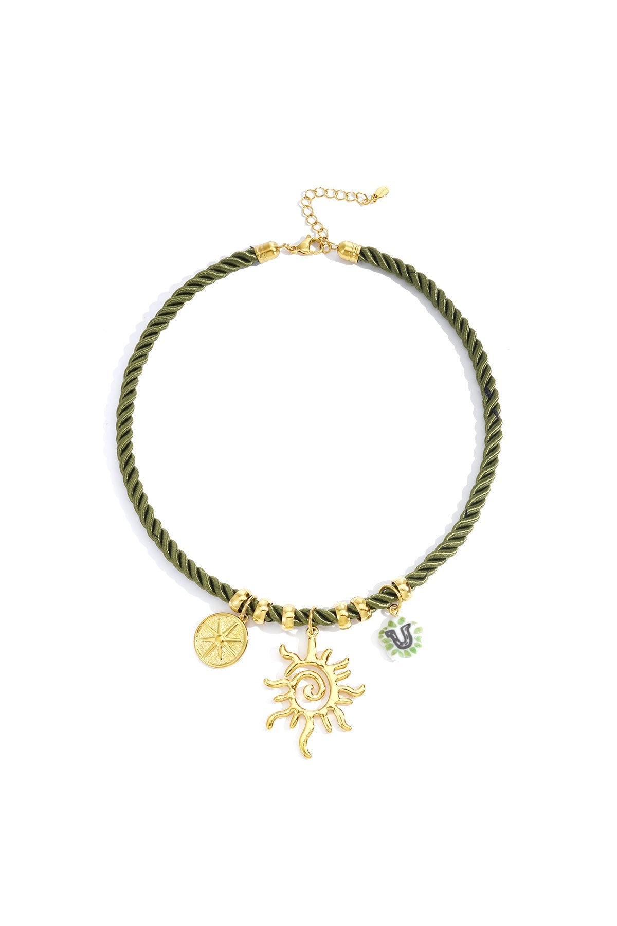 Flat lay of olive green twisted rope necklace featuring gold sun, compass, and green-accented charm charms