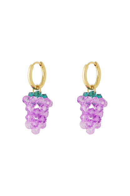 Close-up of gold hoop earrings with dangling purple grape-shaped bead clusters and green tops.