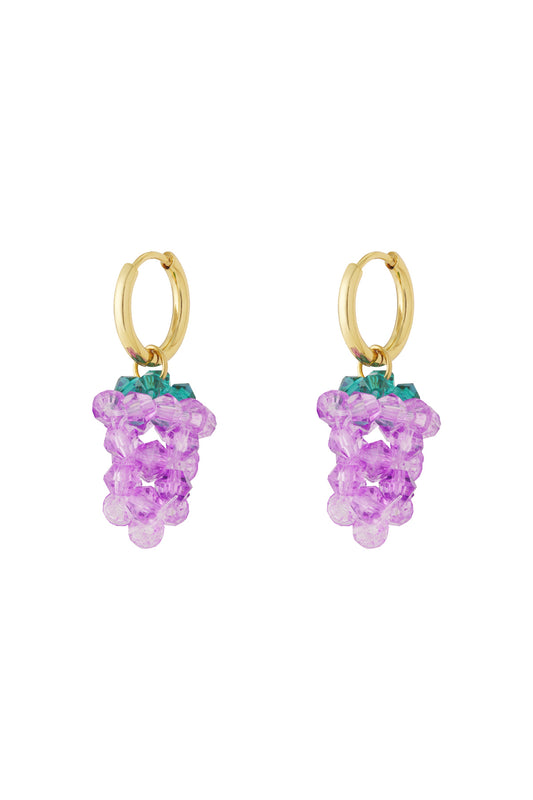 Close-up of gold hoop earrings with dangling purple grape-shaped bead clusters and green tops.