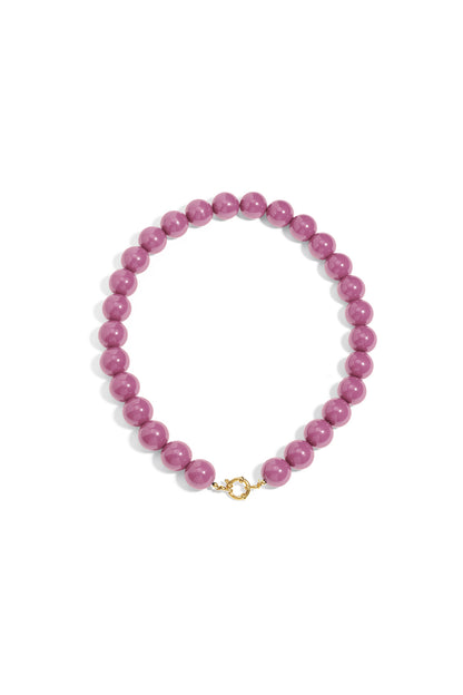 Chunky mauve resin bead necklace featuring a round gold-tone clasp at the front on a plain white background.