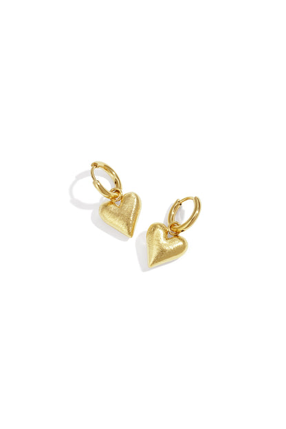 Pair of gold heart charm hoop drop earrings on white background