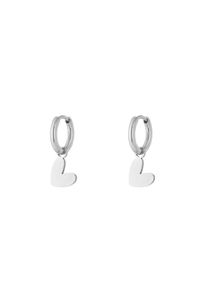 Pair of polished silver heart drop earrings with smooth hoops on plain white background