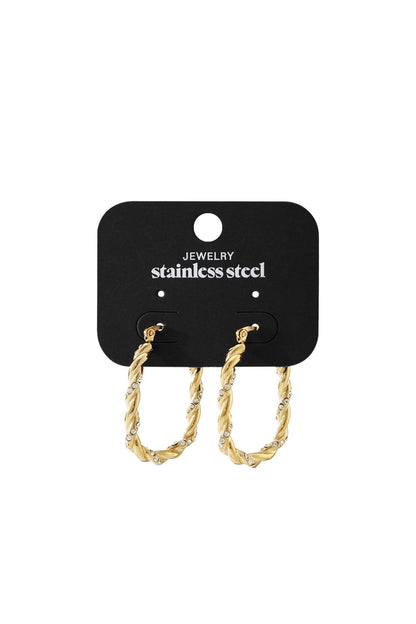 Gold-tone twisted stainless steel hoop earrings featuring embedded clear crystals on a black display card.