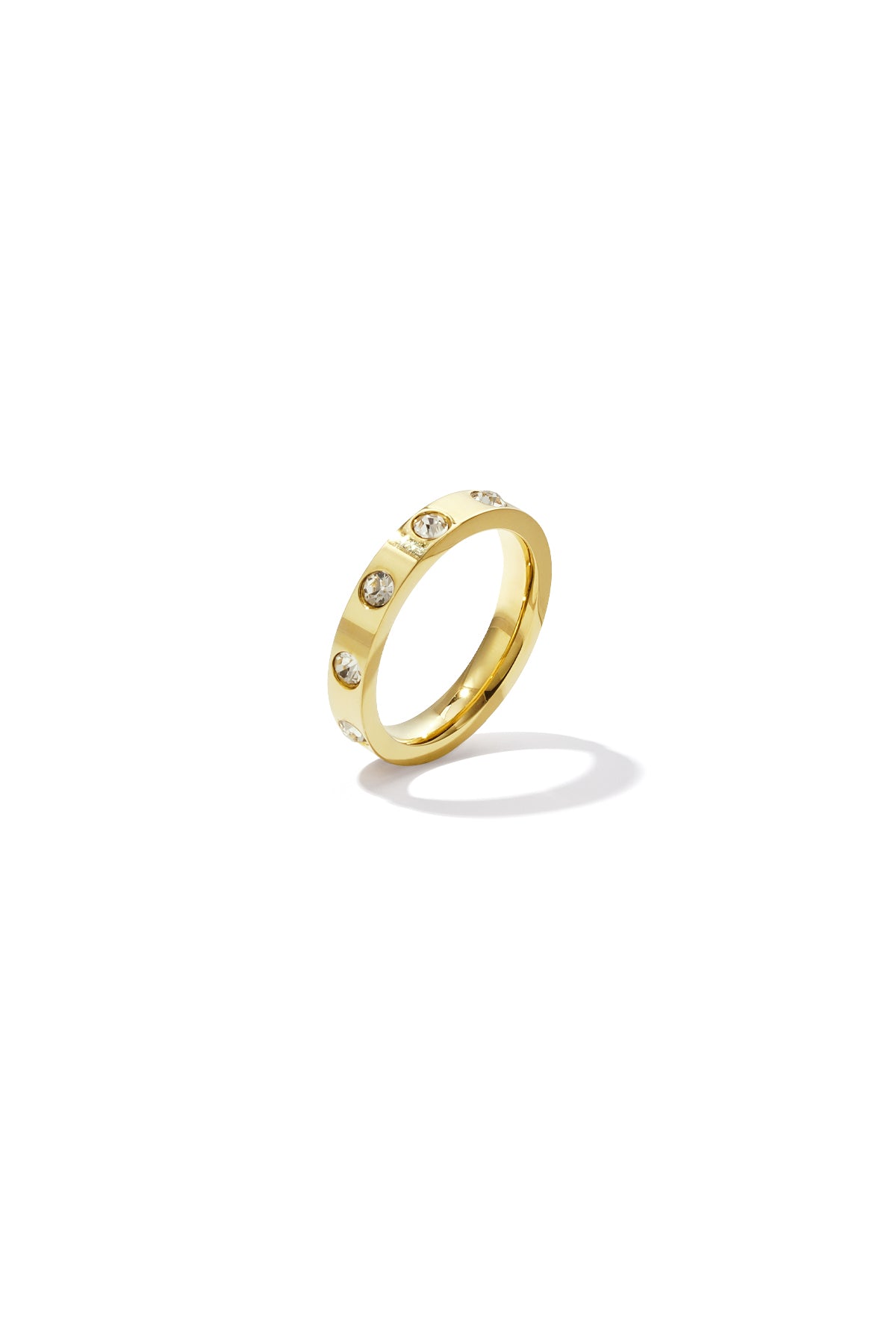 Gold ring with clear crystal accents on polished band, isolated on white background