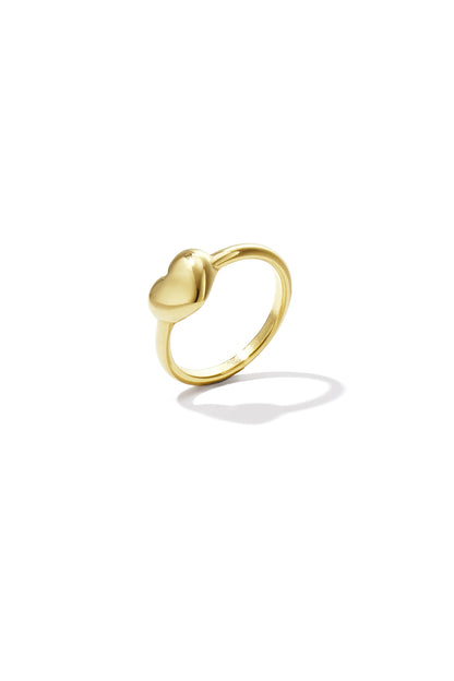 Close-up of a minimalist polished gold ring featuring a smooth heart design on a white background