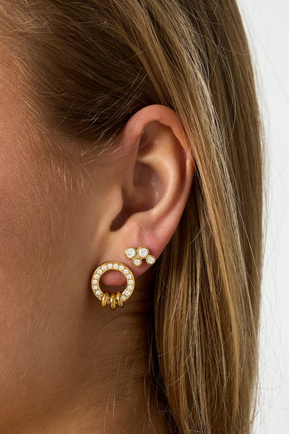 Gold Glitch Orbit stud earrings featuring a crystal-encrusted circle with dangling rings and a matching cluster stud.