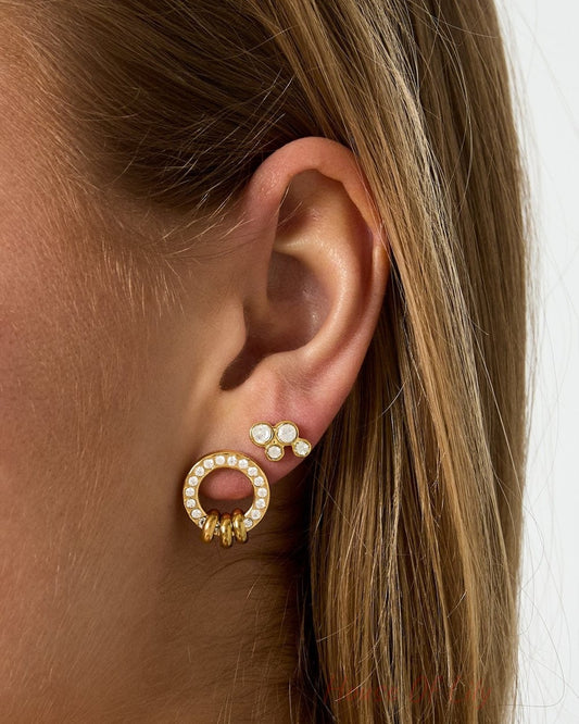 Gold Glitch Orbit stud earrings featuring a crystal-encrusted circle with dangling rings and a matching cluster stud.