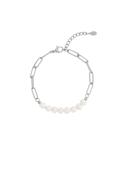 Silver chain bracelet with rectangular links featuring a row of seven white freshwater pearls and a lobster clasp with extender chain