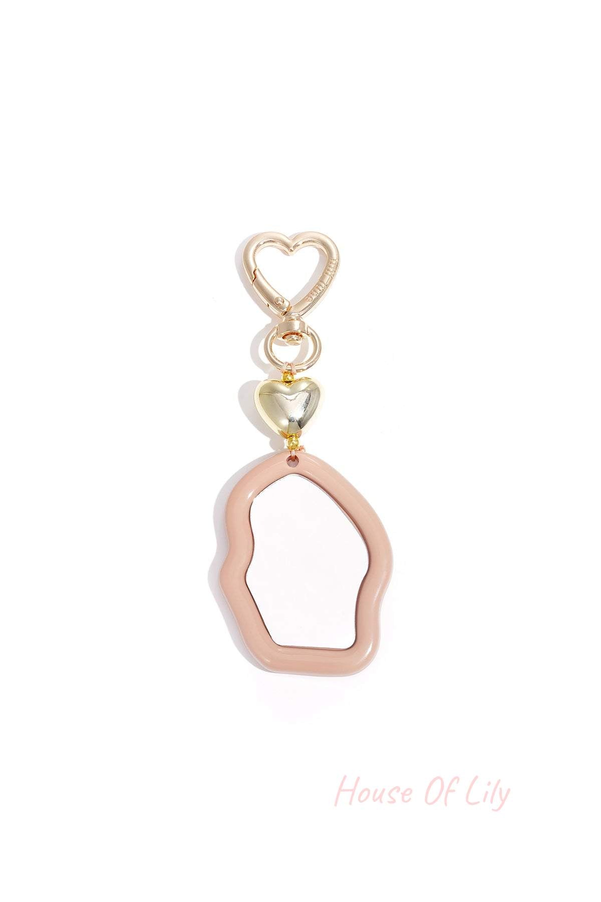 Blush pink acrylic irregular mirror charm with gold heart clasp on white background