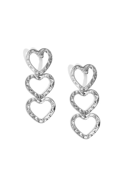 Silver-tone triple heart dangle earrings with hammered texture on white background