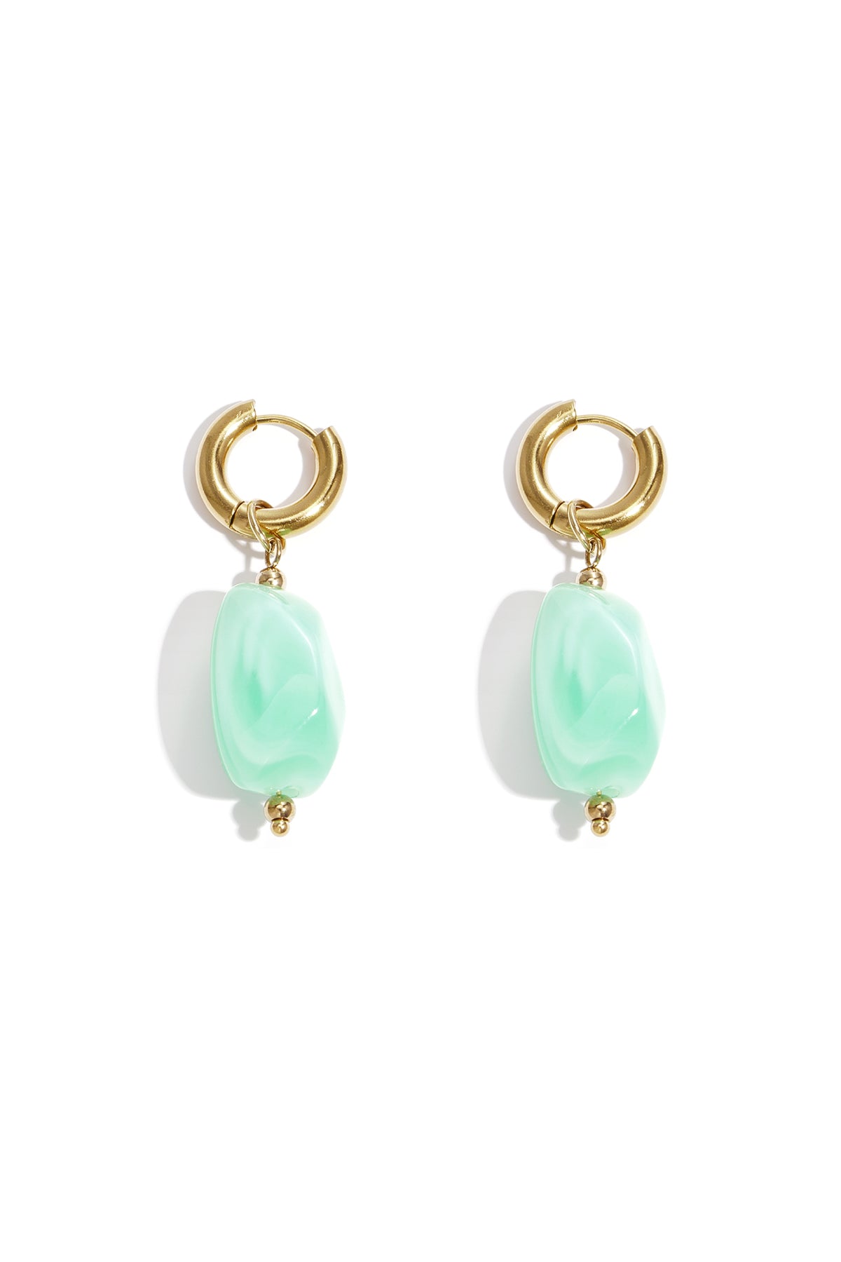 Gold hoop earrings with irregular amber resin drop beads on white background