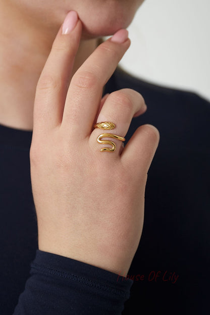 Close-up of hand wearing gold snake statement ring, showcasing the playful and minimal design