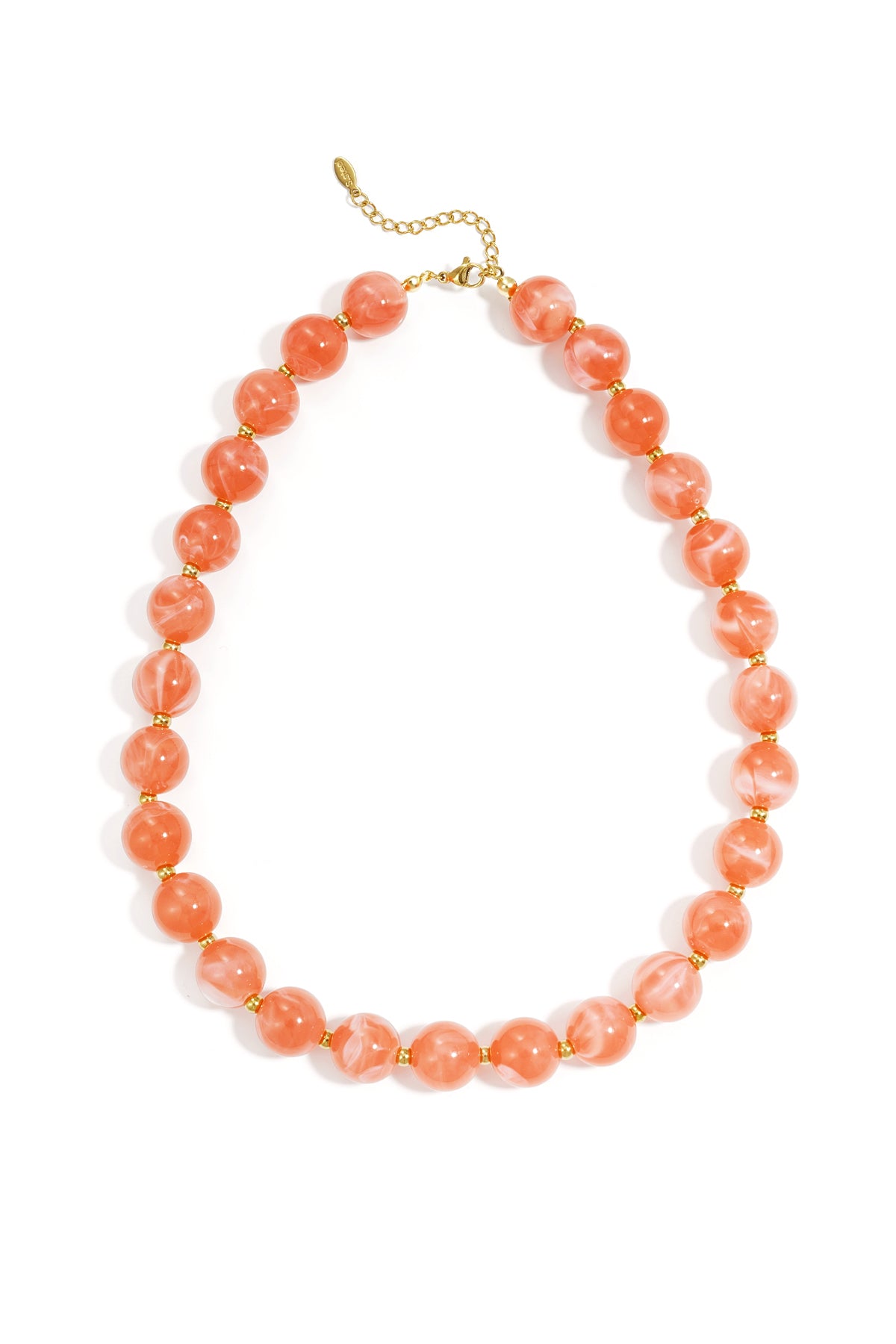 Coral pink beaded statement necklace with gold spacer beads and adjustable gold chain on white background