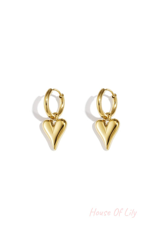 Pair of gold-tone heart-shaped drop earrings with smooth, polished finish against a white background