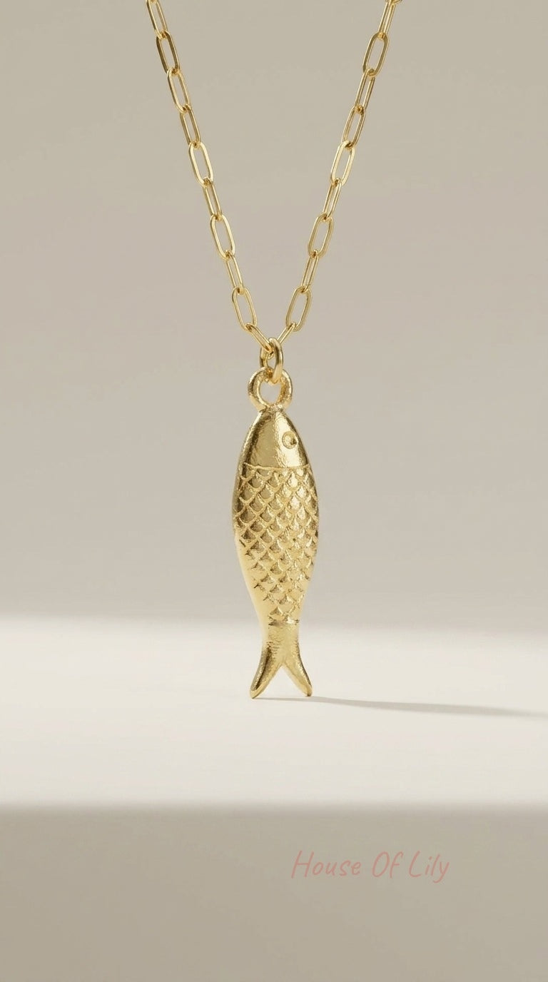 Gold-toned necklace featuring a textured, fish-shaped pendant on a dainty elongated paperclip chain.