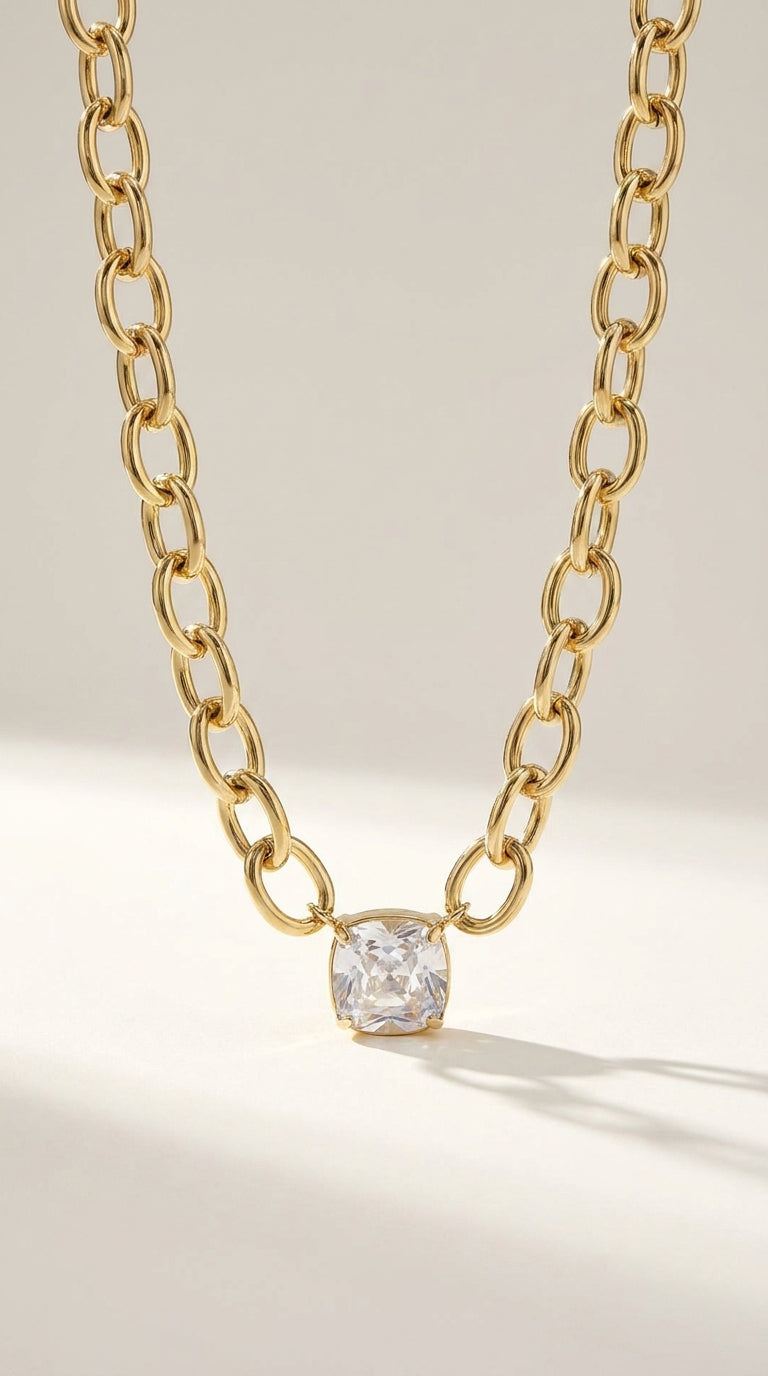 Retro Vibe Pendant: A gold chain necklace with a chunky, oval-link design and a single square-cut crystal pendant.