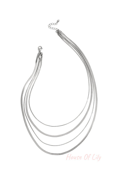 Four-strand silver layered necklace on white background with lobster clasp