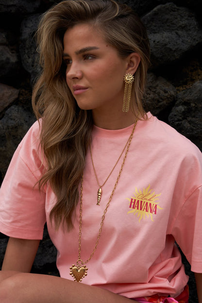 Golden Sunshine dangle earrings featuring a gold sun face stud with cascading fringe chains worn by a woman.