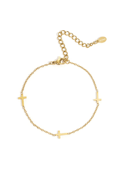 Gold stainless steel delicate chain bracelet with three small cross charms and an adjustable clasp.