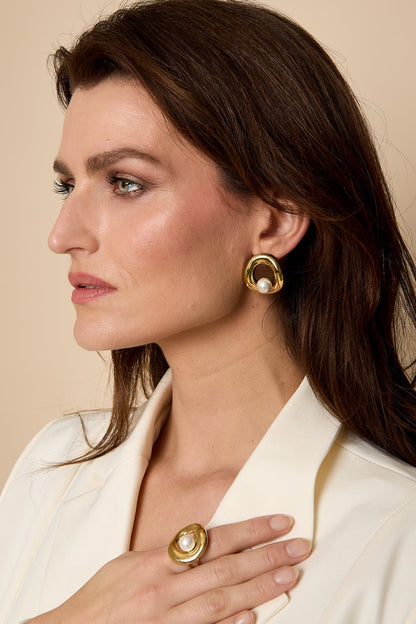 Side profile of woman modeling elegant gold-tone circle pearl stud earring paired with matching ring