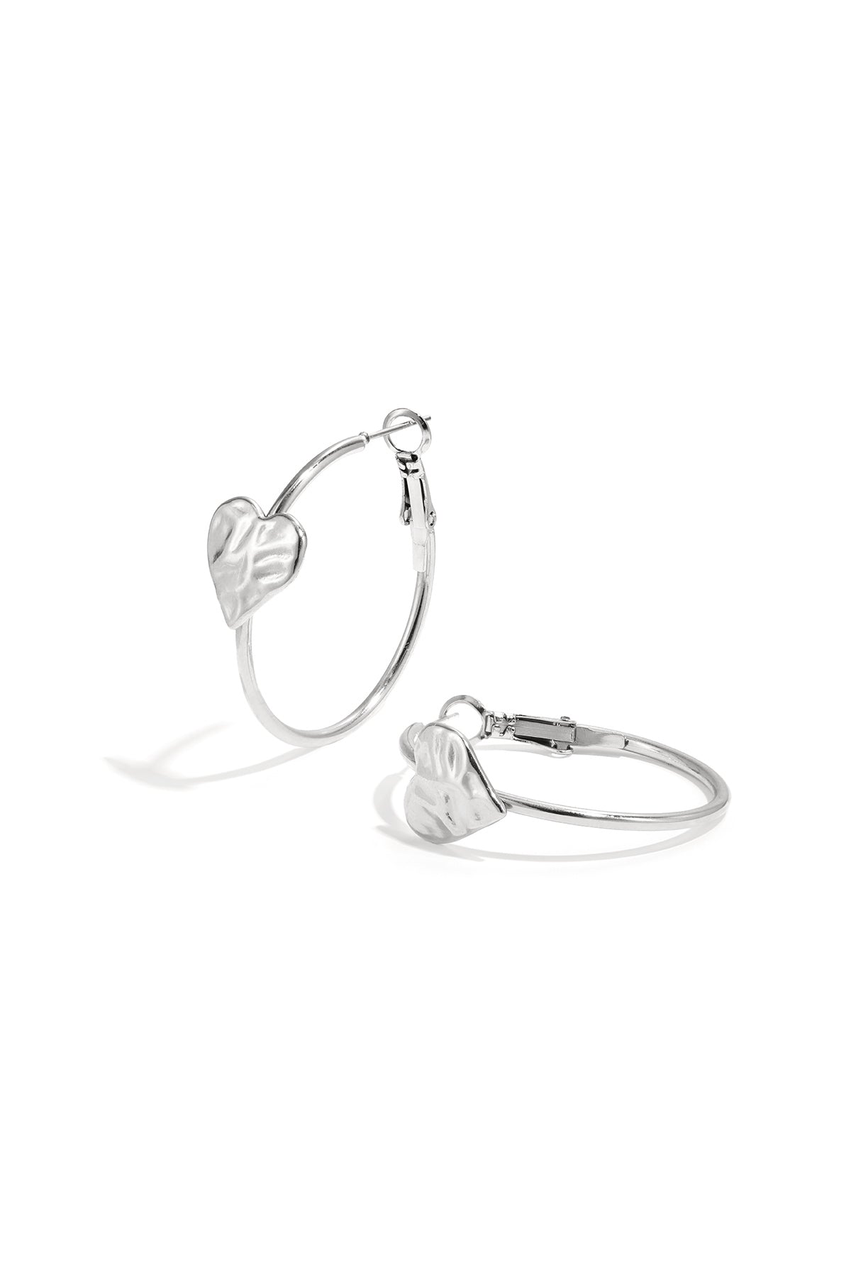 Silver hoop earrings with textured heart detail on white background