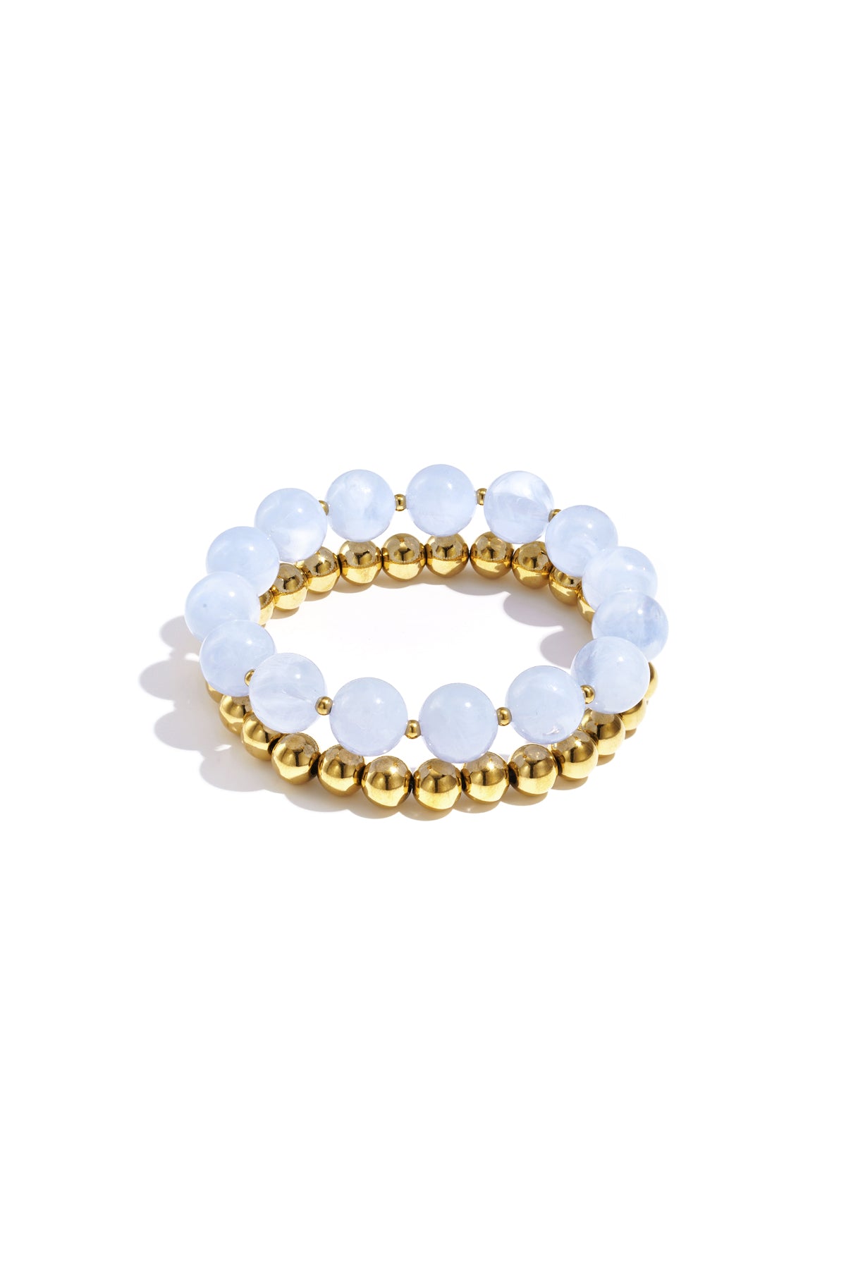 Stack of two bracelets with pale blue round acrylic beads and gold-tone metal beads on white background