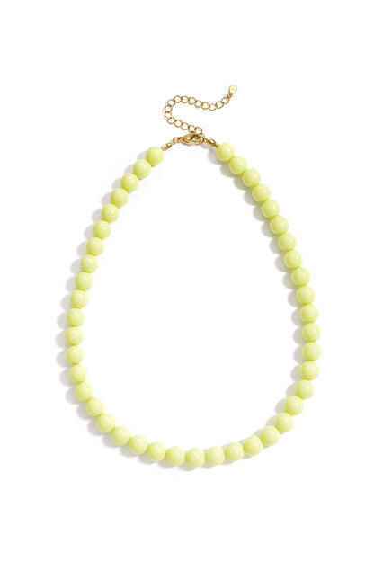 A necklace of round, lime-green resin beads with gold-tone hardware and an adjustable chain clasp against a white background.