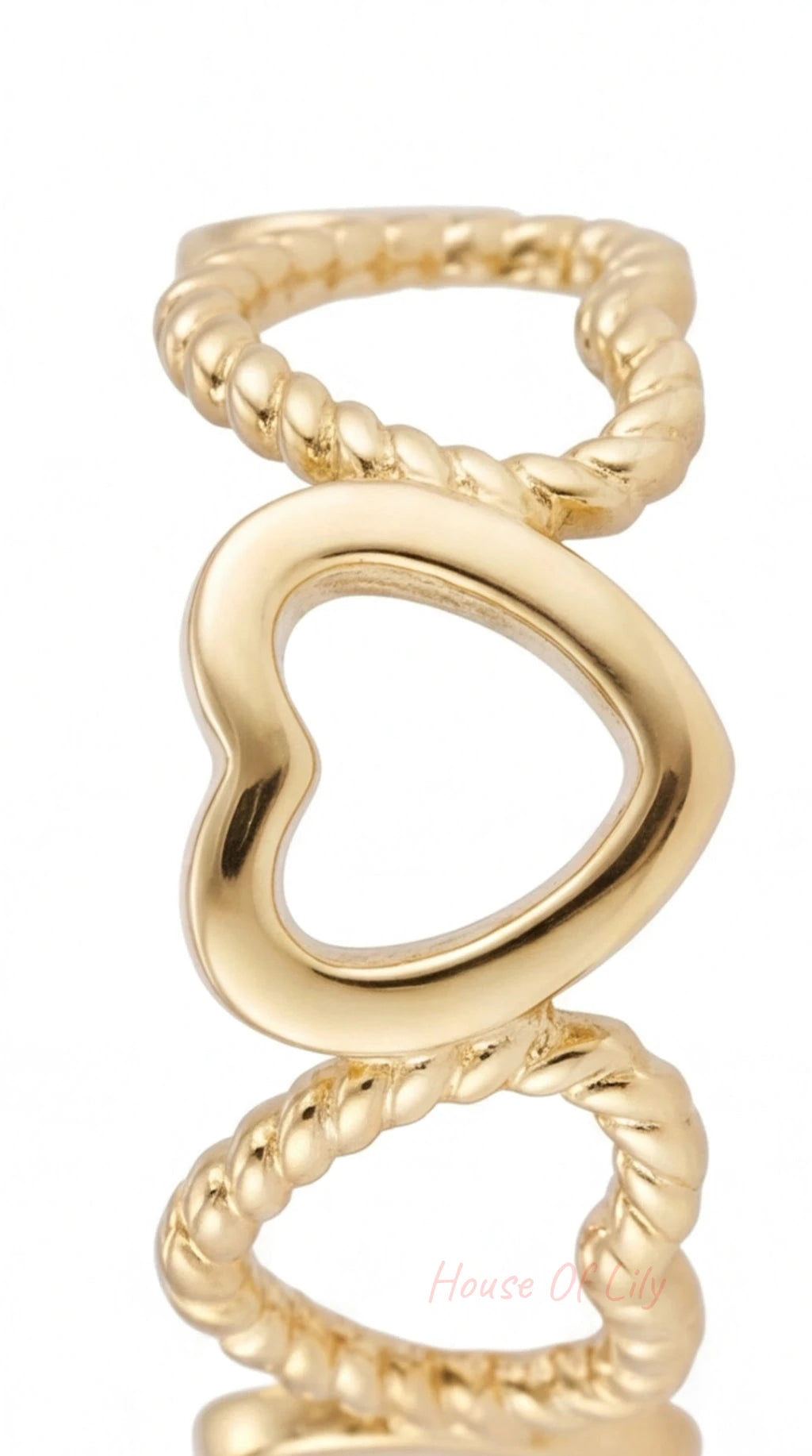 Gold heart-shaped ring on a white background