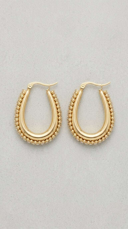 Drip Drop Glow: Gold oval hoop earrings featuring a polished center band framed by delicate beaded crystal edges.