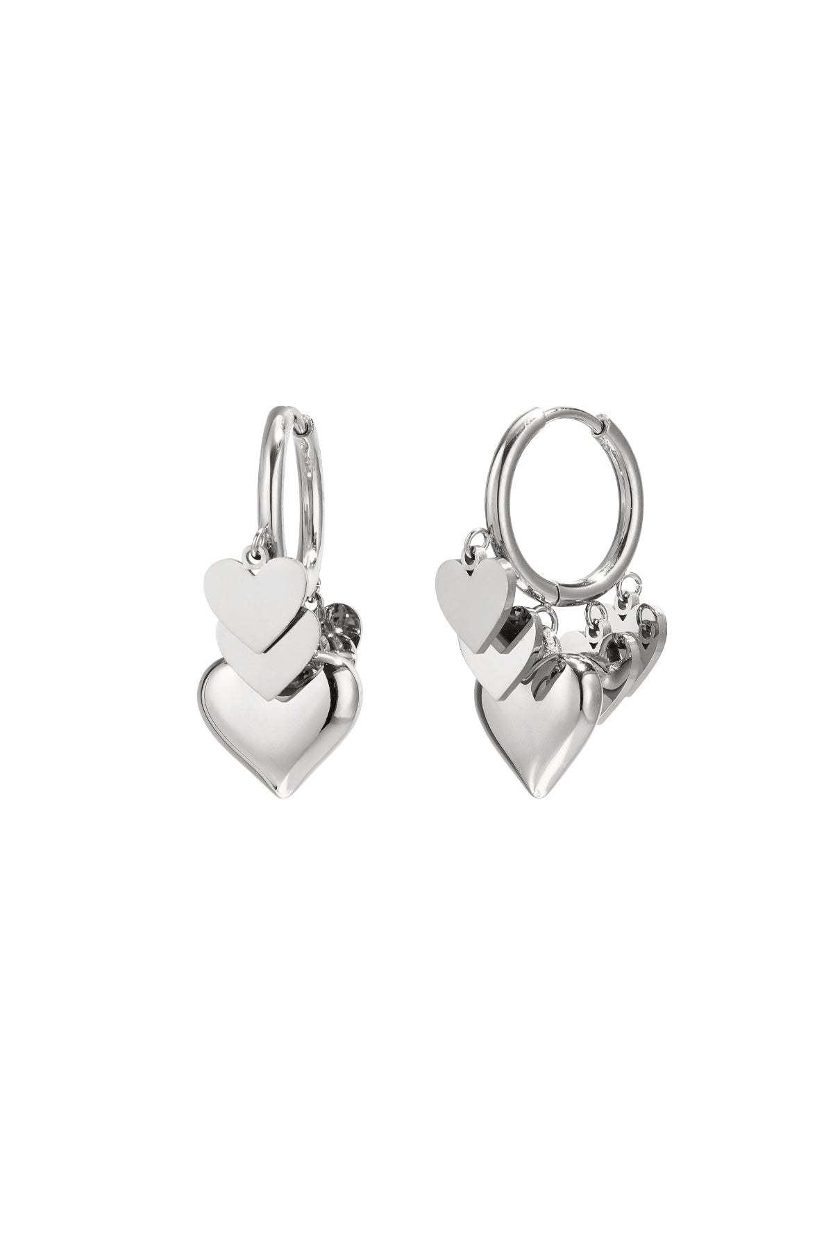Pair of silver drop earrings with three layered heart charms hanging from hoops on white background